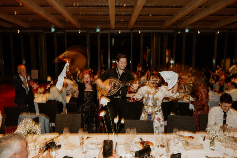 A mucisian at a wedding event making traditional Greek tunes with modern hits and people ae enjoying - wedding DJ Canberra