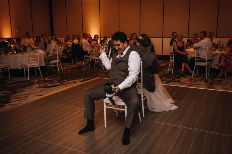 Wedding couple at an event with guests sitting back-to-back on chairs, may be playing musical chair - wedding DJ Canberra