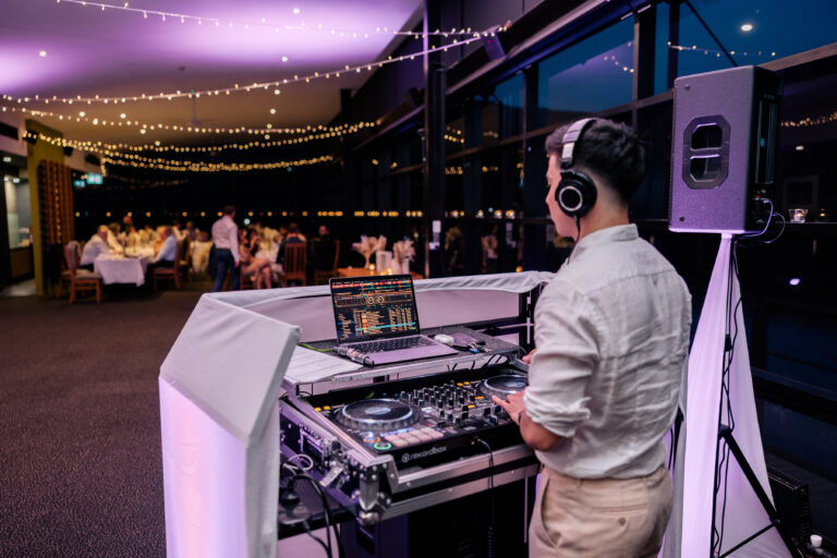 A professional DJ at an event playing beats with the DJ system in front of the crowd, wedding DJ Canberra, 8 til late