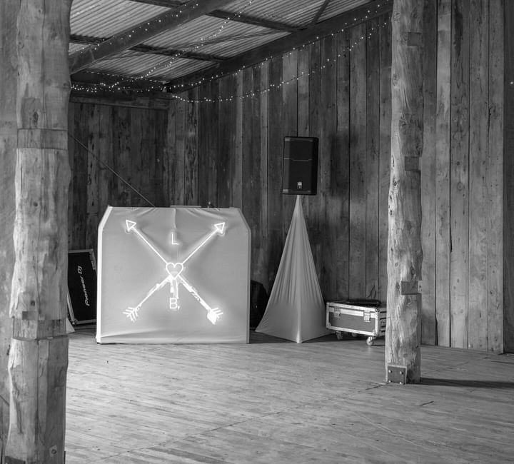 Neon lights forming an arrow sign on a box, surrounded by other event decorative items - wedding DJ Canberra, 8 til late